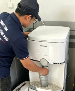 Thợ kiểm tra áp suất bơm và van điện từ cho khách hàng.